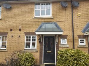 una casa de ladrillo con una puerta y ventanas negras en Double Room in Honiton House, en Hendon