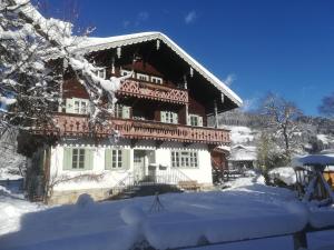ein großes Haus mit Schnee auf dem Boden in der Unterkunft Villa Zeppelin - App Smaragd in Bramberg am Wildkogel