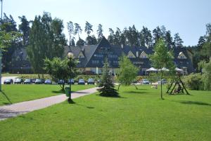 a large building with a park in front of it at AZS Centralny Ośrodek Sportu Akademickiego in Wilkasy
