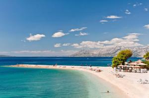 una spiaggia con persone sdraiate sulla sabbia e sull'acqua di Urban Apartments Jadre a Makarska