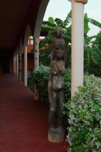 a statue of a woman standing next to a building at Begue Pokai in Toubab Dialaw