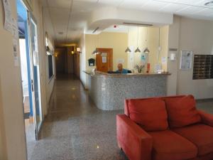 a lobby of a hospital with a couch in front of a counter at Playamarina 2 Reception Cabo Roig in Playas de Orihuela