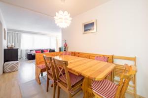 Un comedor con mesa y sillas de madera. en Cristallina A2, en Laax 3 fotos más