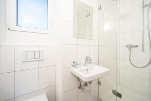 a white bathroom with a sink and a shower at Cristallina A2 in Laax