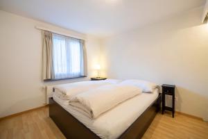 una cama grande en una habitación con ventana en Cristallina A2, en Laax