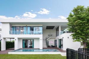 a house with a swimming pool in front of it at Itz Time Hua Hin Pool Villa in Hua Hin