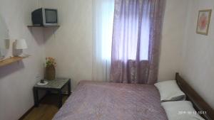 1 dormitorio pequeño con 1 cama y TV en Economy Hotel Lira, en San Petersburgo