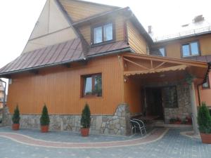 a house with a gambrel roof with a patio at GÓROLIK u Kwietniów-nocleg & śniadanie, tel 18-20-010-31 in Bukowina Tatrzańska