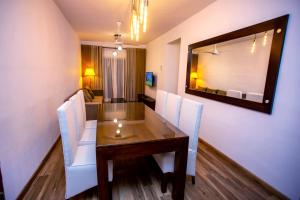 高爾的住宿－Seabreeze Apartment，餐桌、白色椅子和镜子