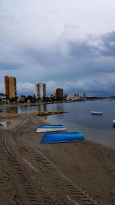 a group of blue boats on the shore of a beach at Pensión K-Hito in Santiago de la Ribera