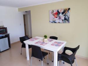 a white table with black chairs and a painting on the wall at CENTRO RENT APART in Federación