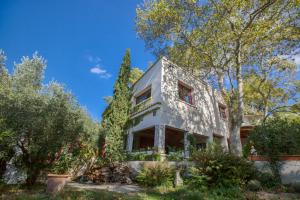 an exterior view of a white house with trees at Duché d'Uzès Villa Celina Avenue des Cévennes in Uzès