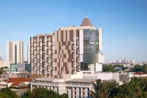 a large building in front of a city at Novotel Jakarta Cikini in Jakarta