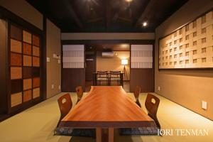 uma sala de jantar com uma mesa de madeira e cadeiras em IORI Stay em Takayama