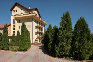 un gran edificio con árboles delante de él en Grand Hotel en Brasov