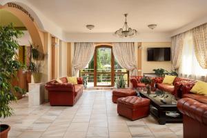 a living room with leather furniture and a large window at Grand Hotel in Braşov