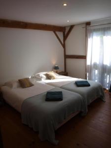 una camera da letto con un letto grande con due cuscini sopra di Grand gîte Gastes a Gastes