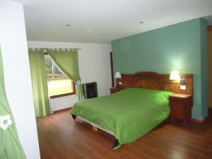a bedroom with a green bed and a window at Cabaña Milla Antü, Villa la angostura in Villa La Angostura