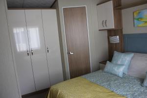 Dormitorio pequeño con cama y armario en Life Begins @ 40 Sun Valley Park, en St Austell