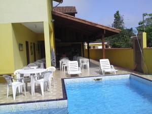 eine Terrasse mit Tisch und Stühlen und ein Pool in der Unterkunft Makitub in Boracéia