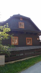 una casa negra con ventanas y una valla en Valašské chalupy Resort en Velké Karlovice