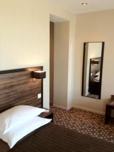 Pokój hotelowy z łóżkiem i lustrem w obiekcie LES ARCADES w mieście Dieppe