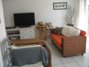 a living room with a couch and a flat screen tv at Floris'Home in De Haan