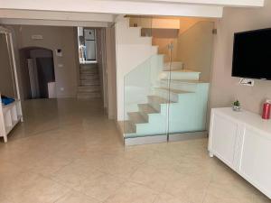 a living room with a staircase and a television at Suite Sui Tetti Apartment in Bari