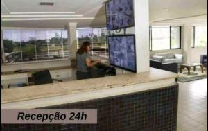 a woman standing at a counter in an office at Flat mobiliado praia, João Pessoa PB PROMOÇÃO in Cabedelo +30 photos