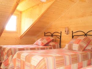 a bedroom with two beds in a wooden cabin at Cabañas de Madera El Rinconcillo in Arroyo Frio