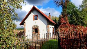 uma casa branca com um telhado vermelho e uma cerca em Dworek de Janauis em Kościerzyna