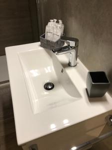 un lavabo blanco con un dispensador de jabón. en B&b estercarlo en Trezzo sullʼAdda