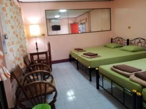 a room with two beds and a mirror and chairs at Punnpannsuk in Trat