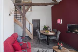 een woonkamer met een rode bank en een tafel bij De Stal in Kaatsheuvel