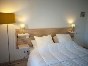 a bedroom with a large white bed with two lamps at Appartement B16 onde Marine in Port-Vendres