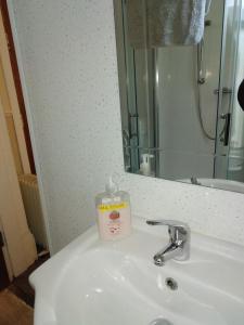 a bathroom sink with a bottle of soap on it at Tuxford House in Blackpool