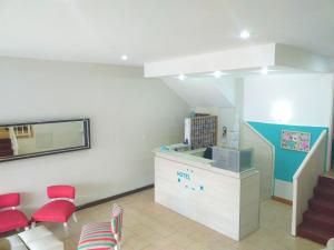 una sala de espera con sillas rojas y un mostrador en Hotel Avellino, en Mar del Plata
