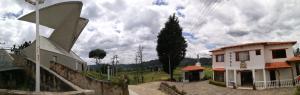 un bâtiment avec un arbre et une maison dans l'établissement Hotel El Cangrejo, à Paipa