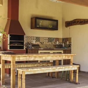 a kitchen with a table and a tv on the wall at Cabanas Mahalo in Imbituba