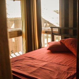 a bedroom with a bed next to a window at Cabanas Mahalo in Imbituba