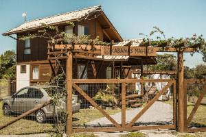 a house with a wooden gate in front of it at Cabanas Mahalo in Imbituba