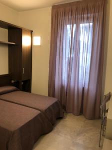 1 dormitorio con 1 cama y una ventana con cortinas moradas en B&b estercarlo en Trezzo sullʼAdda