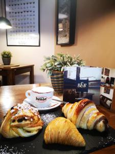 una mesa con pan y cruasanes y una taza de café en CASA MARINA en Nápoles