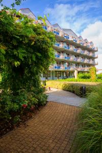 a large apartment building with a walkway in front of it at Wyspa Uznam - Apartamenty Zdrojowa in Świnoujście