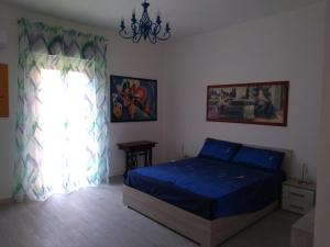 een slaapkamer met een blauw bed en een raam bij Casa Otello in Siracusa