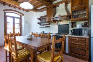 a kitchen with a wooden table and wooden chairs at Agriturismo Bioli in Querceto