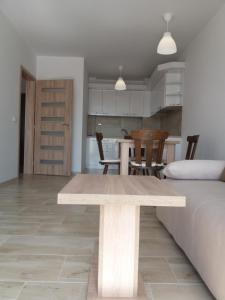uma sala de jantar e cozinha com uma mesa de madeira em Лукс апартамент Алекс em Blagoevgrad