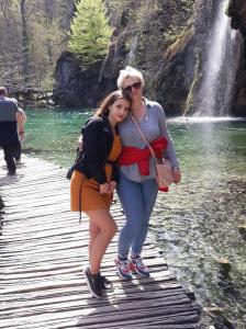 two women standing on a bridge near a waterfall at Apartments New Charming in Senj