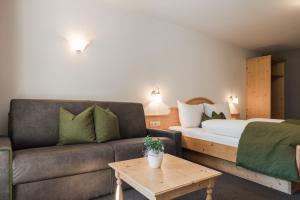 Hotel Kesslwirt في Ciardes: غرفة معيشة مع أريكة وسرير