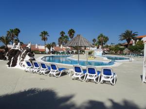 a group of chairs and a pool at a resort at Appartamento Indipendente in Villa - Golf Del Sur in San Miguel de Abona